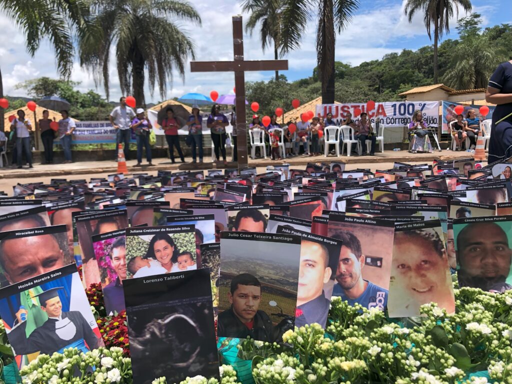 hundreds of photos of faces are displayed beneath a cross