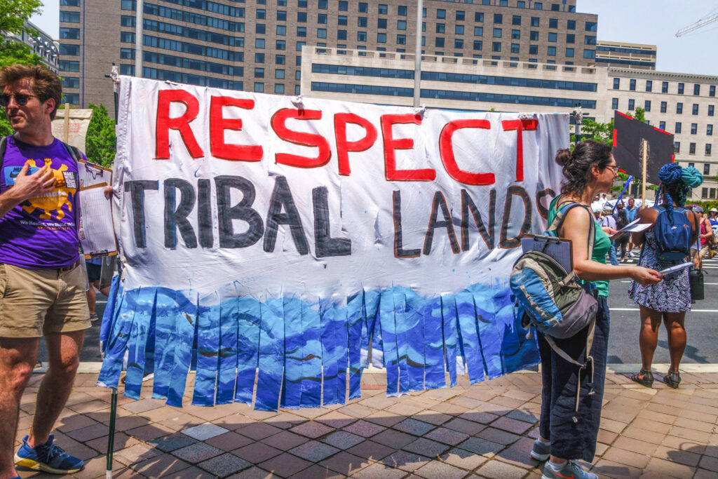 Activists with Respect Tribal Land sign