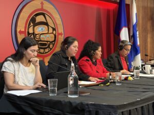 four people at a press conference table